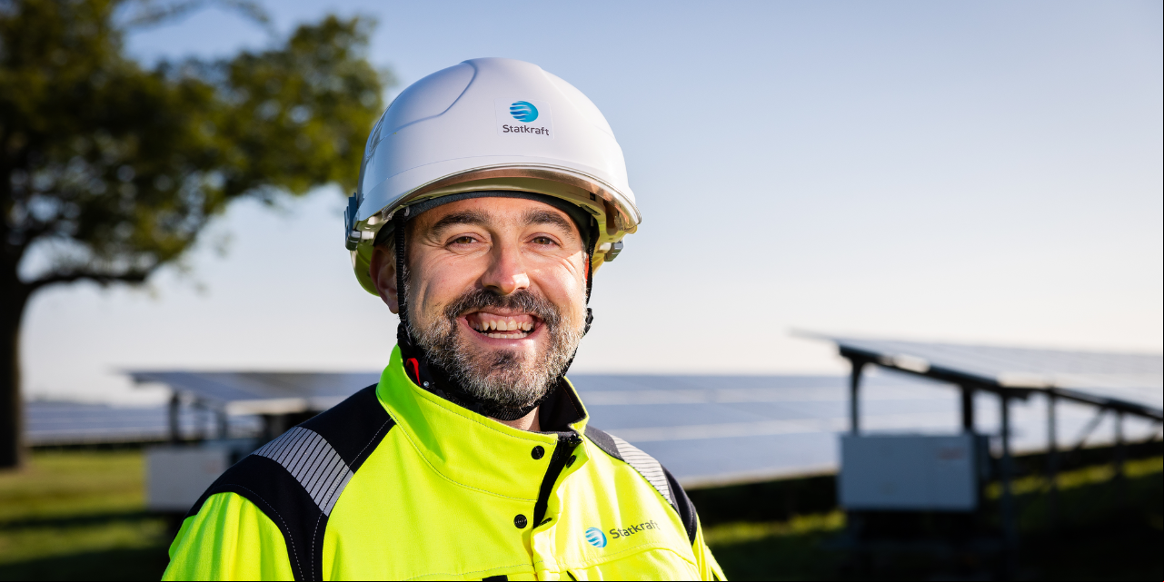 Um retrato de homem sorrindo em um parque solar.
